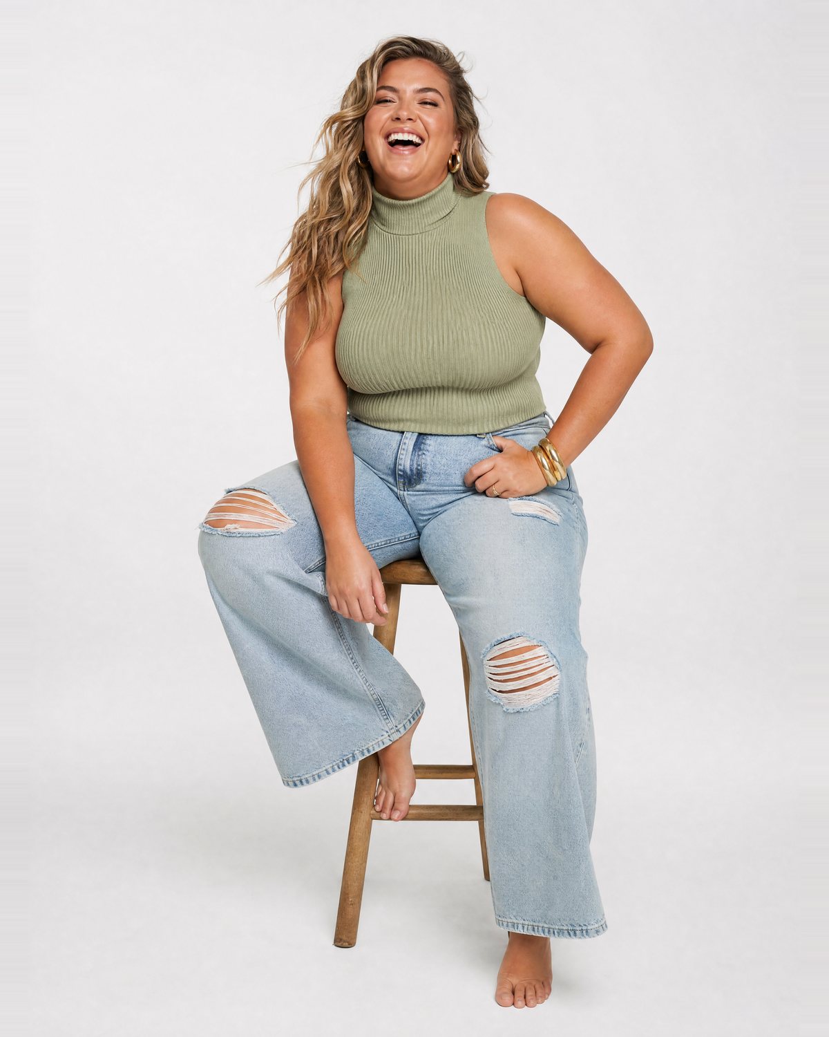 A woman sitting on a stool, laughing
