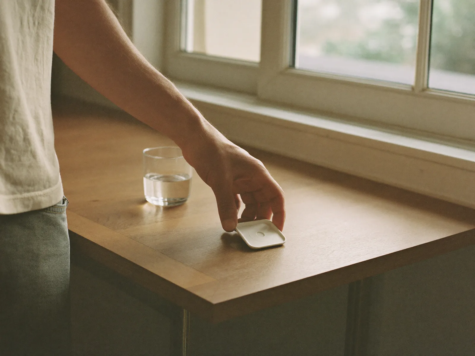 The once-daily tablet beside a glass of water in soft morning light